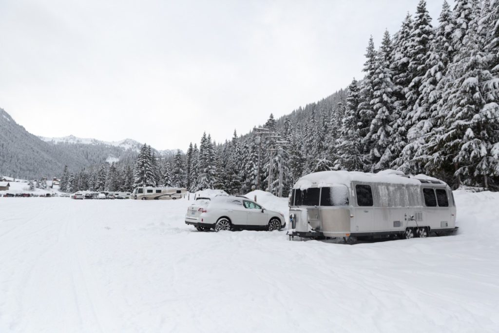 Snow covered Airstream with trees
