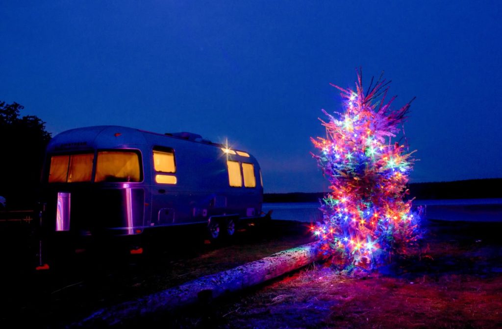 Airstream lit up Christmas tree at night