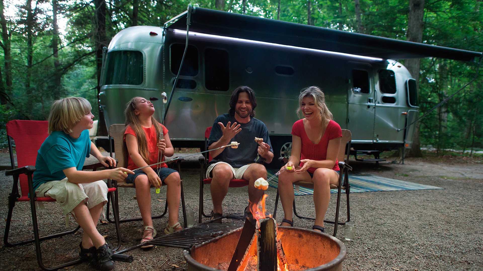 Family-Traveling-Together-by-Fire-Pit-Airstream-Flying-Cloud