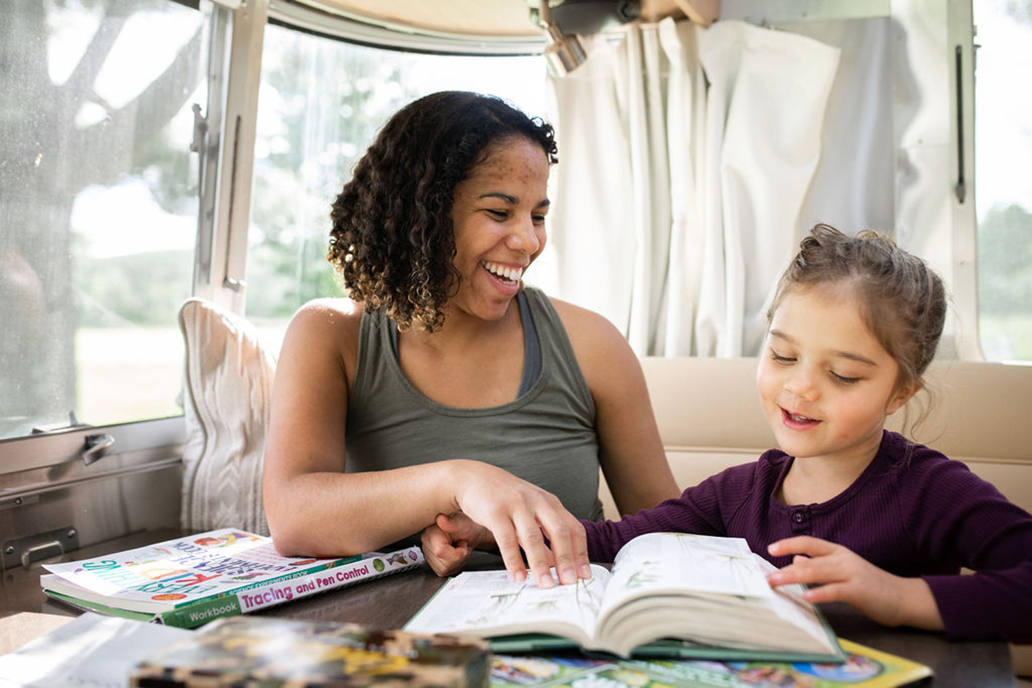 A mom and her daughter doing school work in their Airstream Travel Trailer