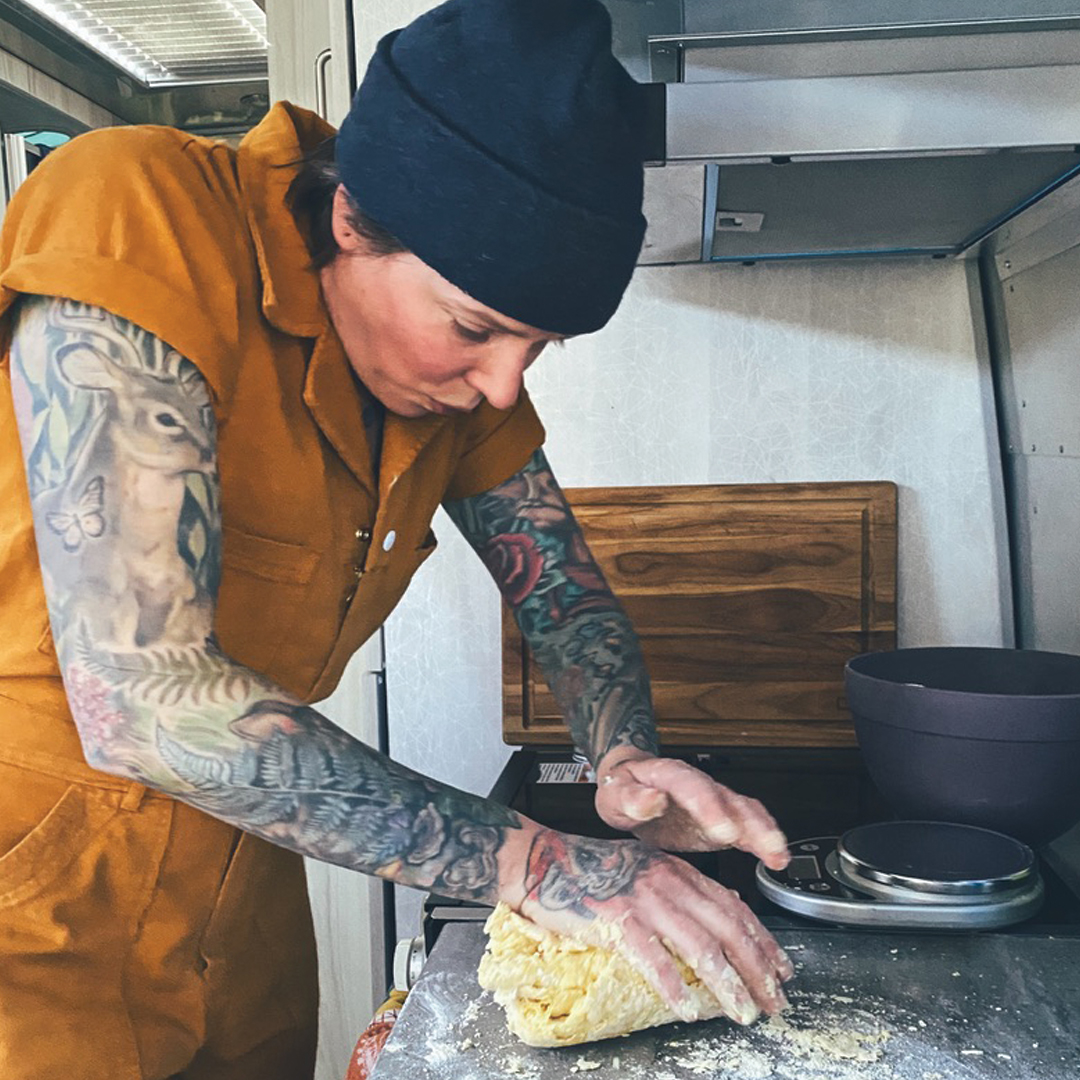 Regan kneading dough for pasta on a counter inside of an Airstream