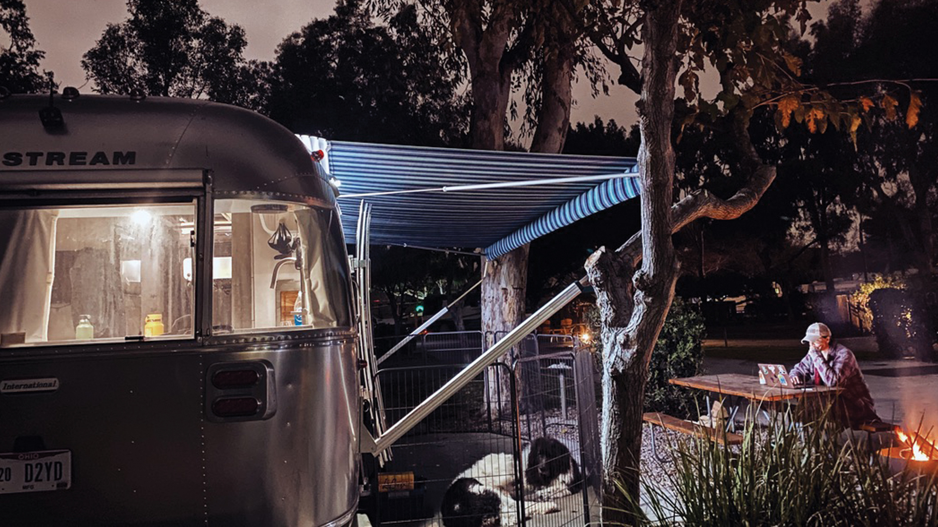 Editing a book sitting at a table outside of her Airstream