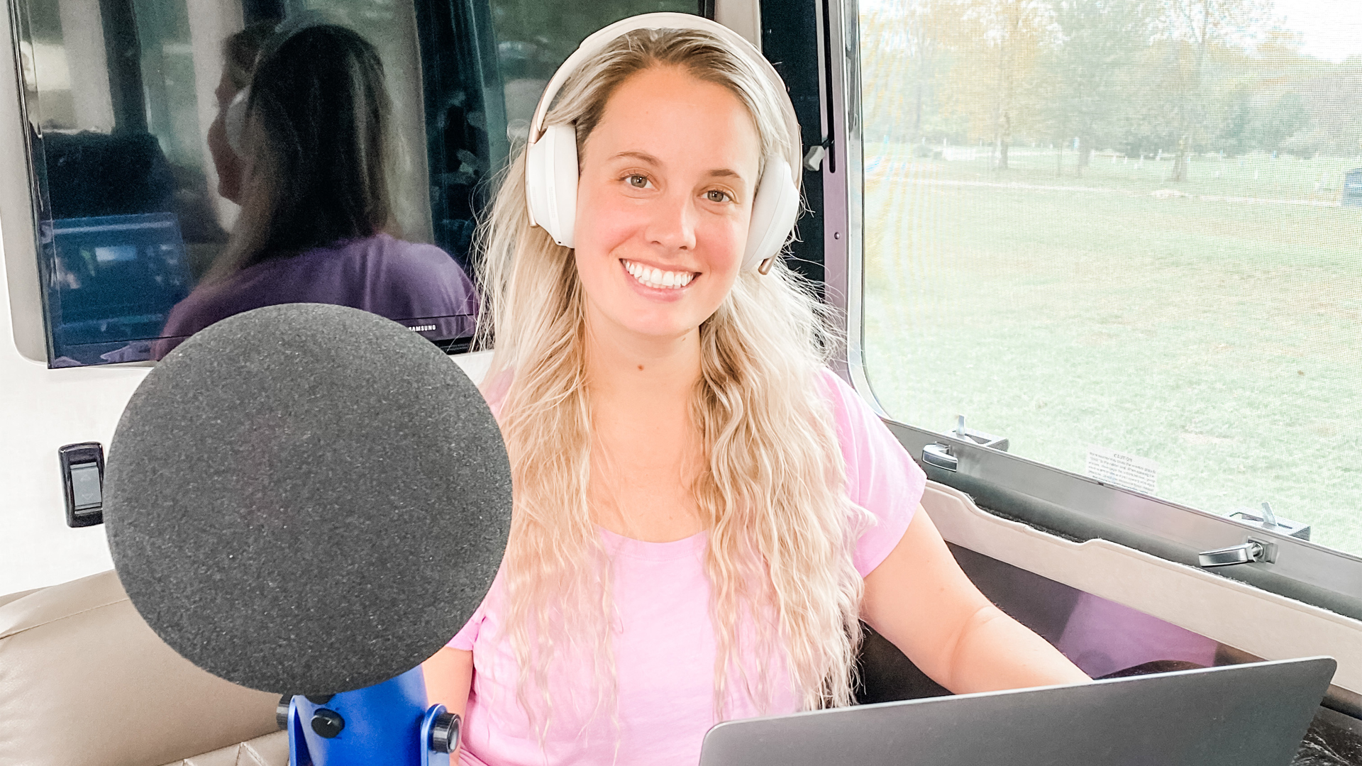 Lauren sitting in the galley of her Airstream Travel Trailer creating a podcast