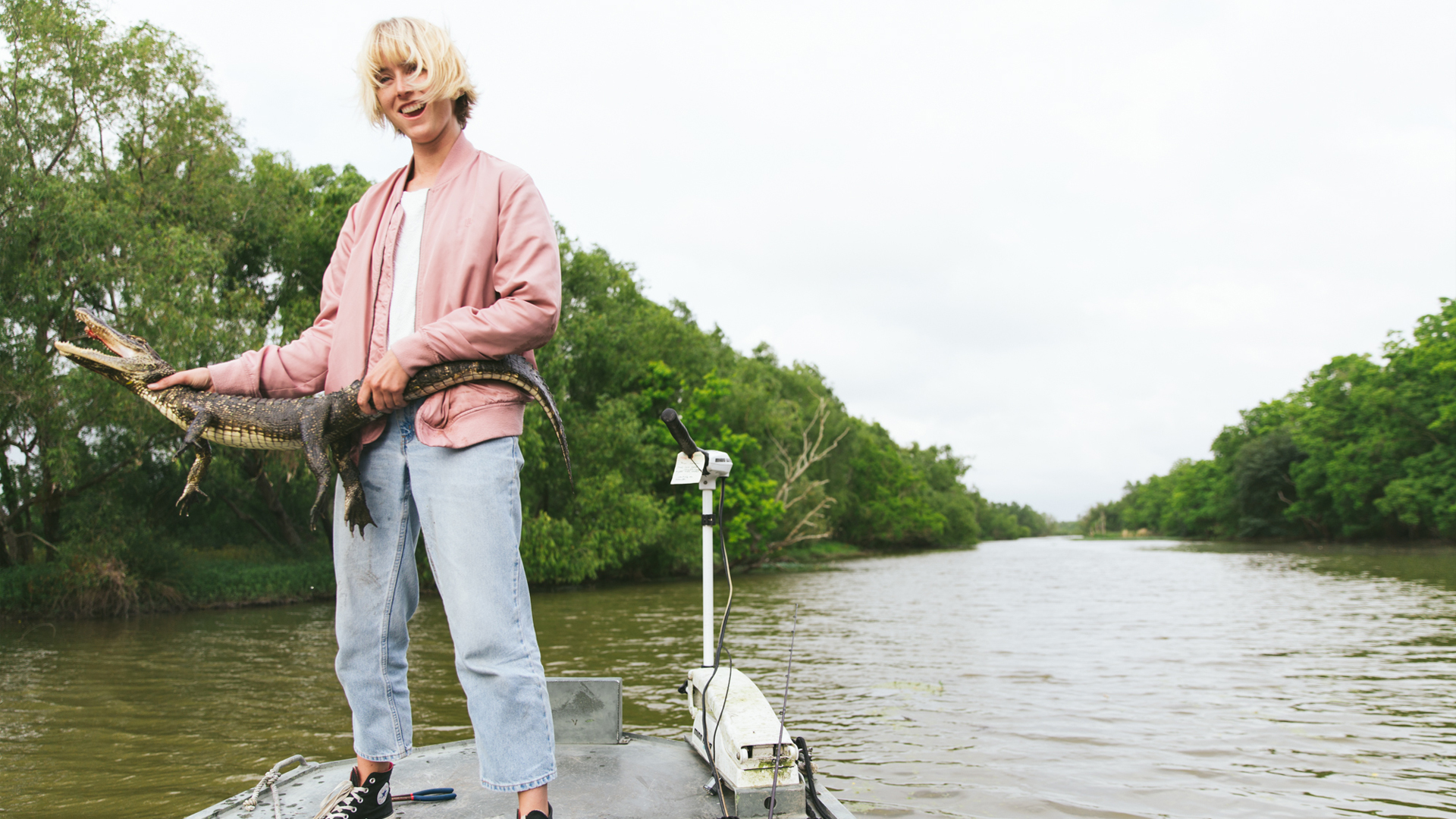 Laura Austin holding an alligator on a boat