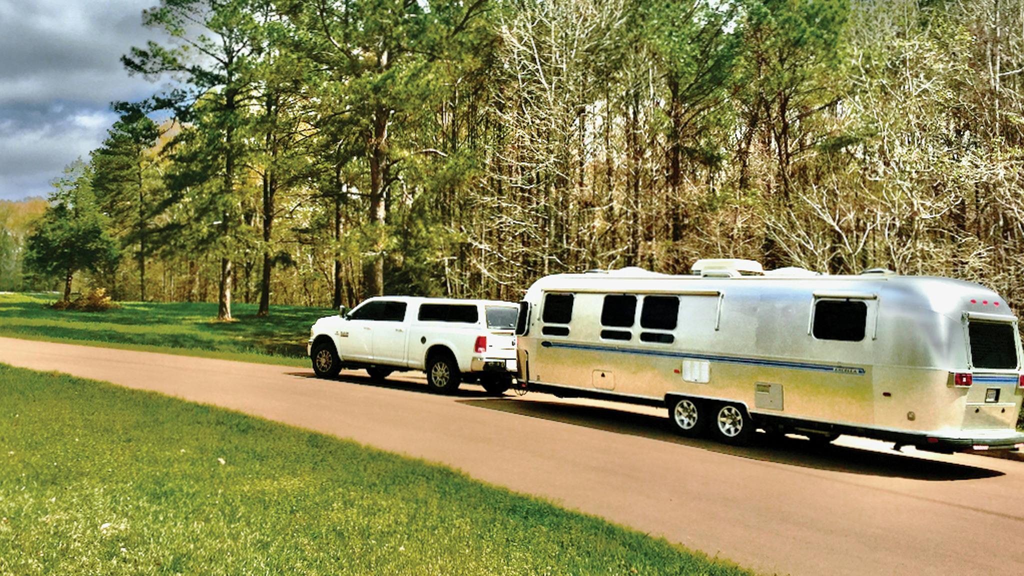 Airstream named Beauty driving down a lane