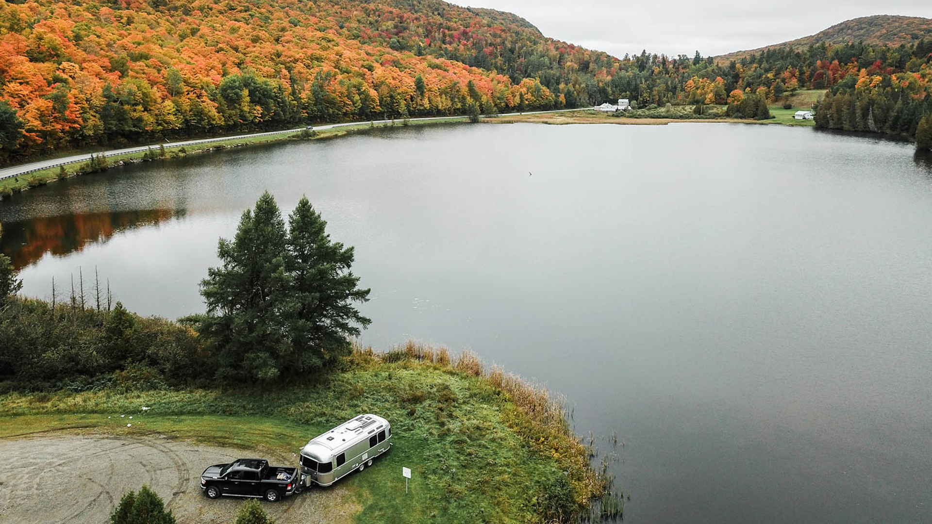 Airstream Travel Trailer at a campground in the fall by a lake