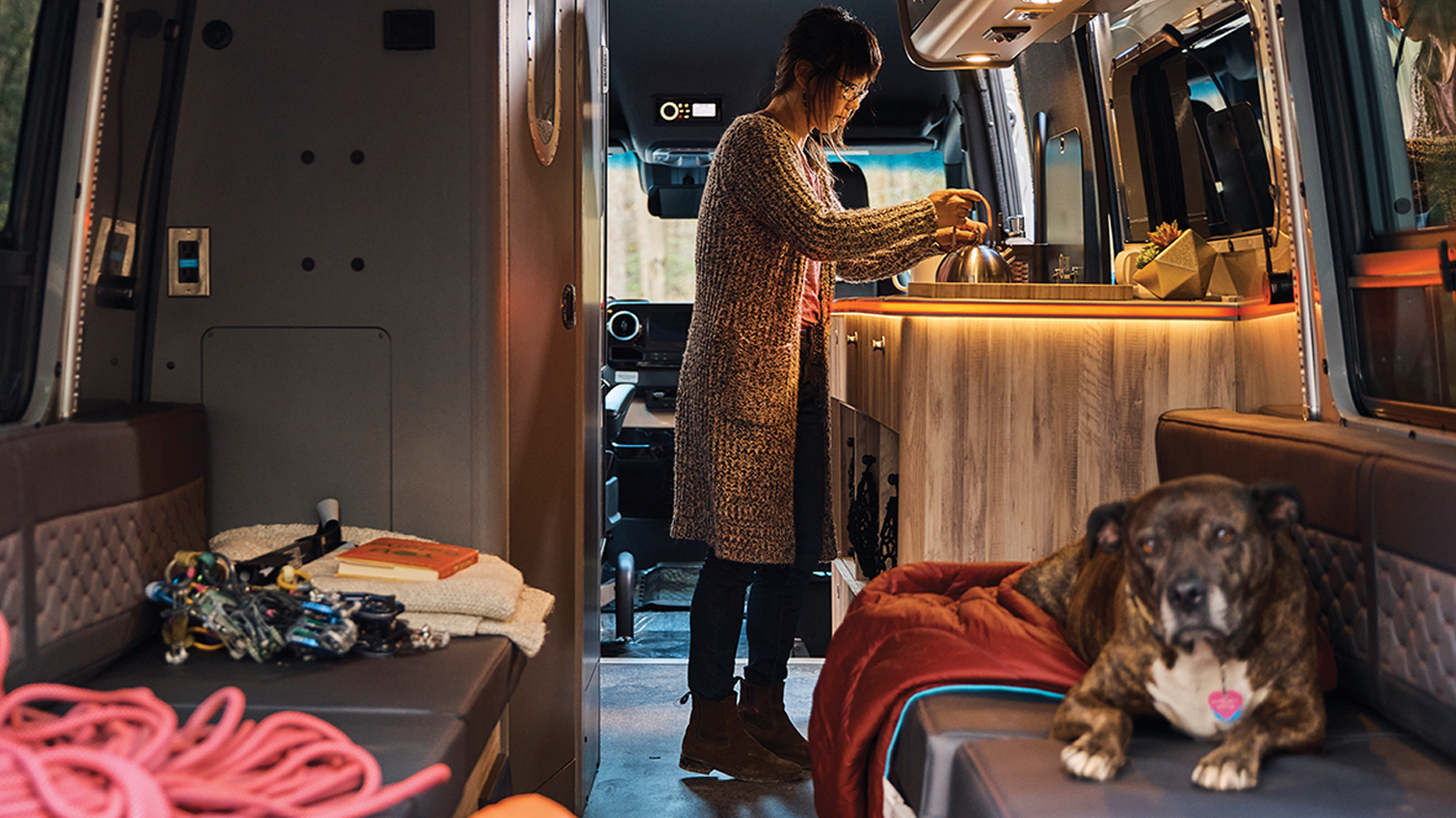 A woman cooking on the stove of her Airstream Interstate 24X