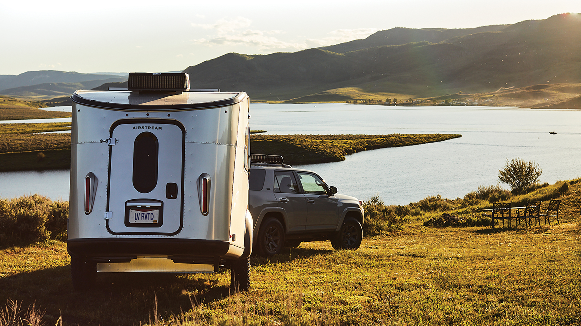 Airstream Basecamp being towed through the grass