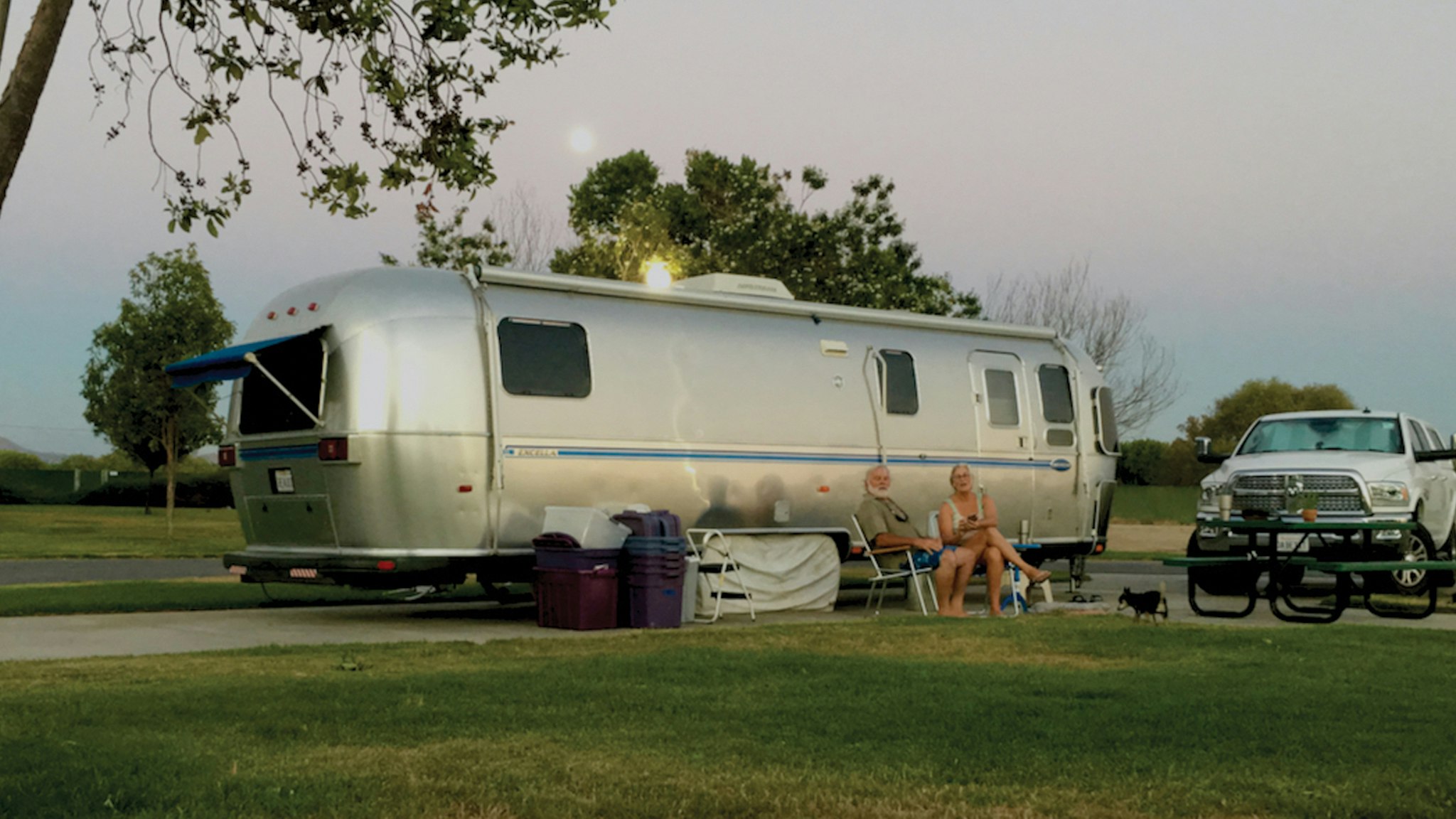 Jim and Carmen sitting outside of their Airstream Travel Trailer