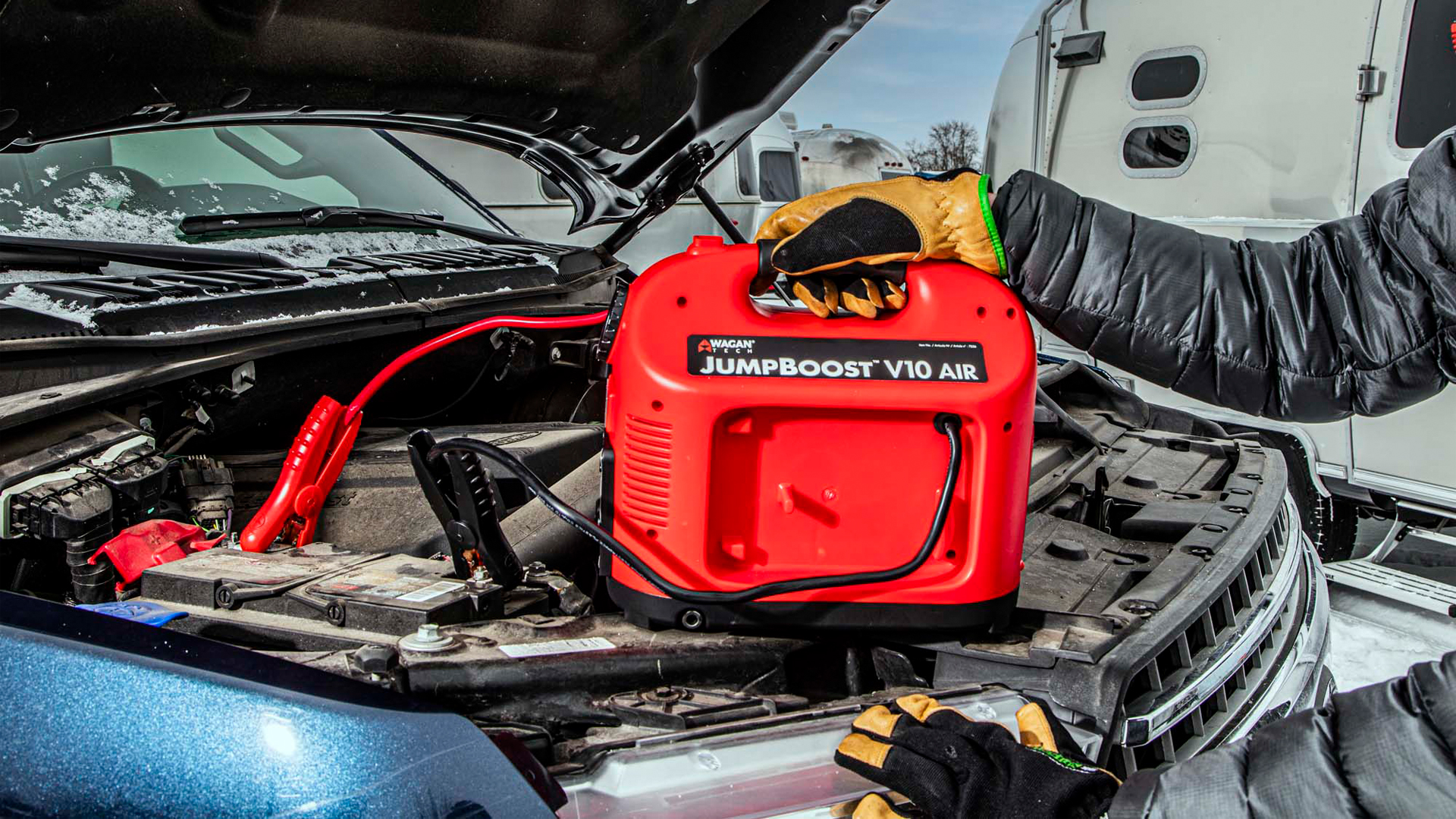 A portable jump starter being used on a tow vehicle for an Airstream travel trailer.