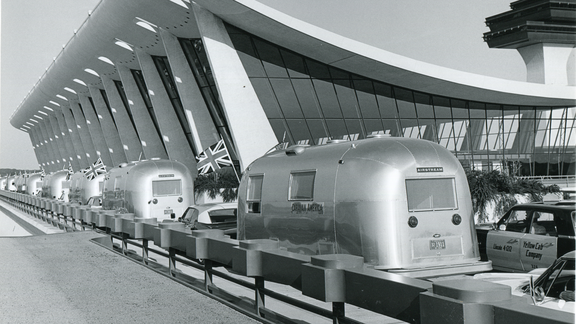 Airstream travel trailer's lined up next to a building with a Britian flag