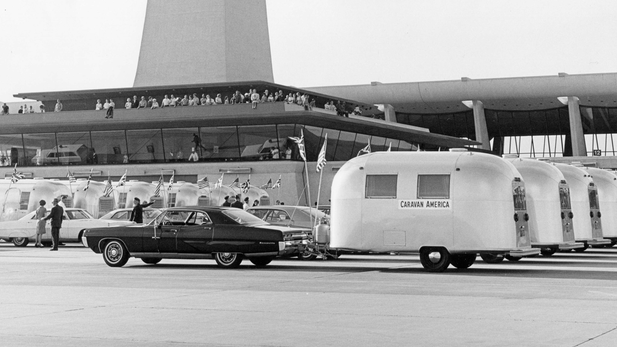 Airstream travel trailers lined up in front of a tall building during Airstream's Caravan America