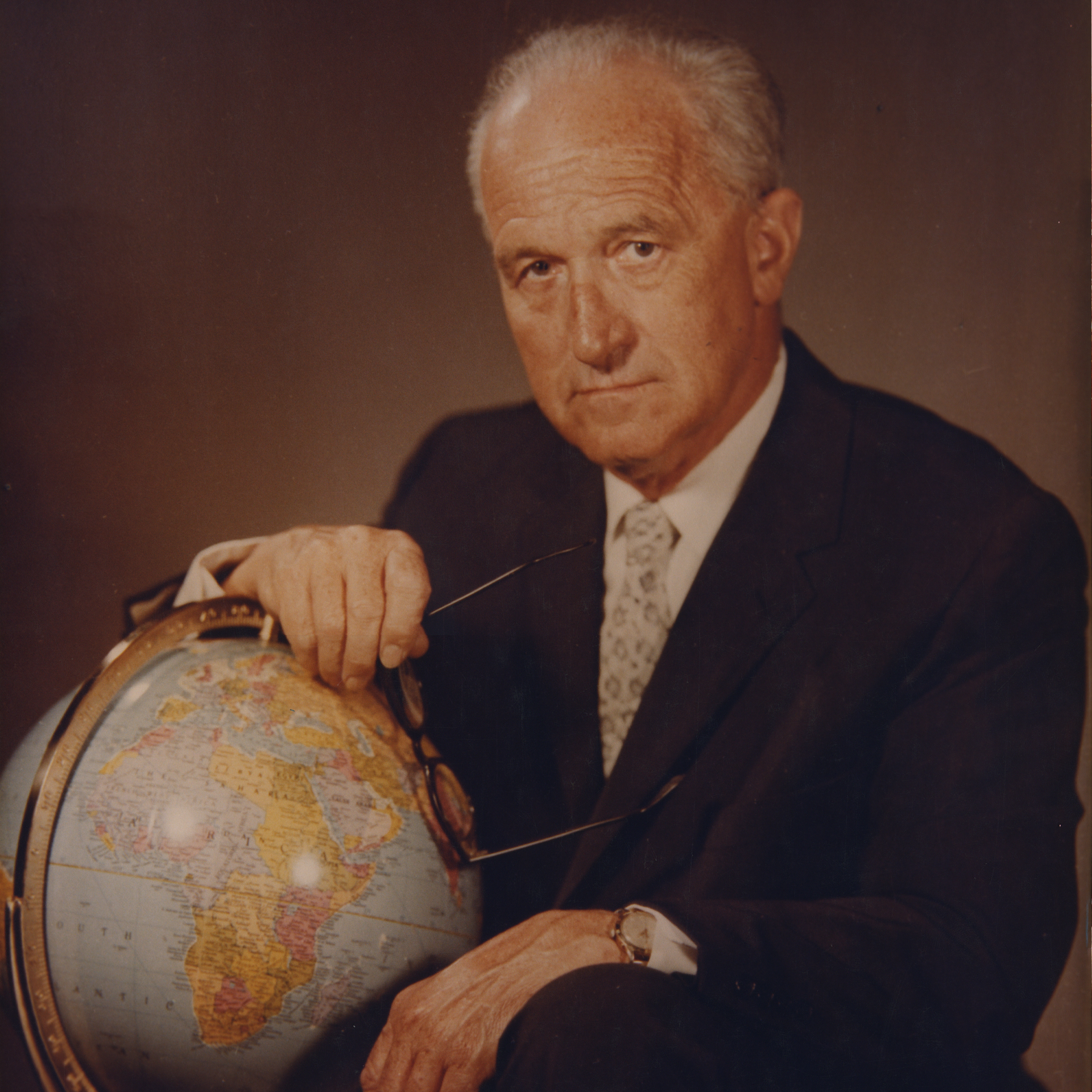 Wally Byam's portrait image holding a globe