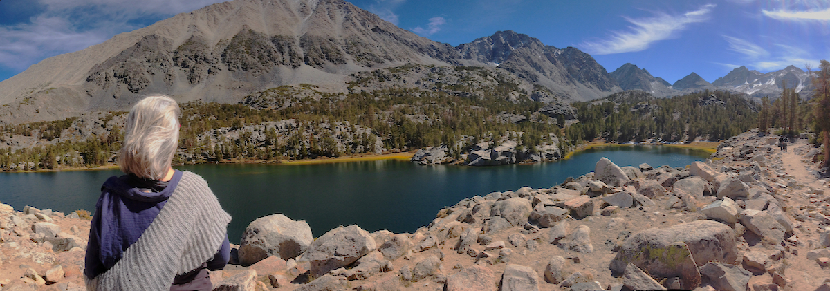 Carmen looking out at a lake that is next to a mountain at a national park.