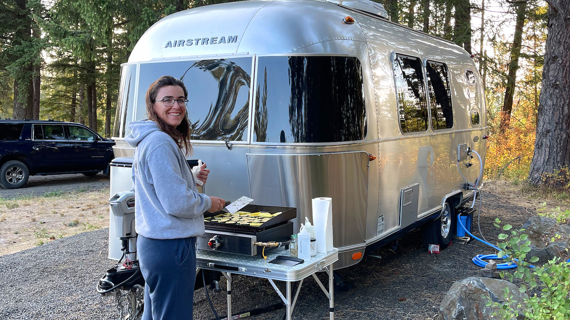 Dorsey Addicks cooking on a grill outside of her Airstream Flying Cloud