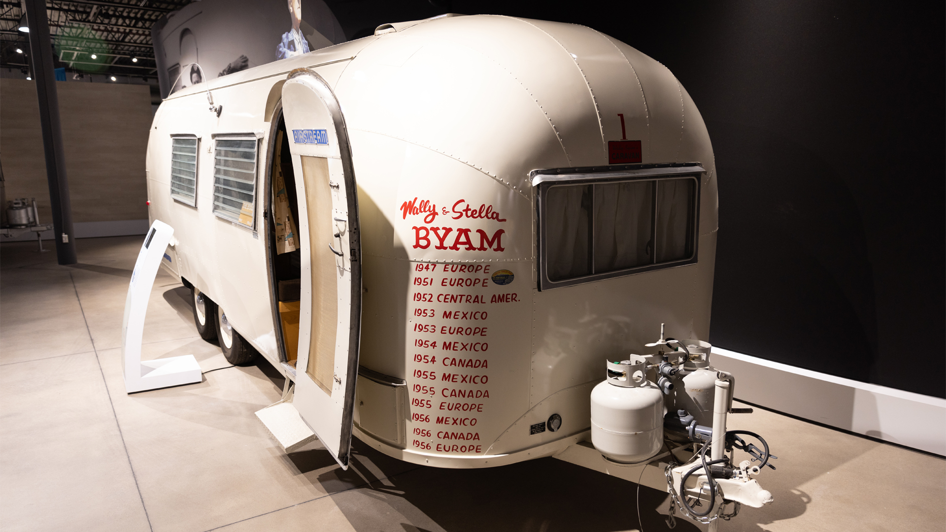 Red writing on the front of the Airstream vintage white trailer with the places it has been with Airstream foudner Wally Byam