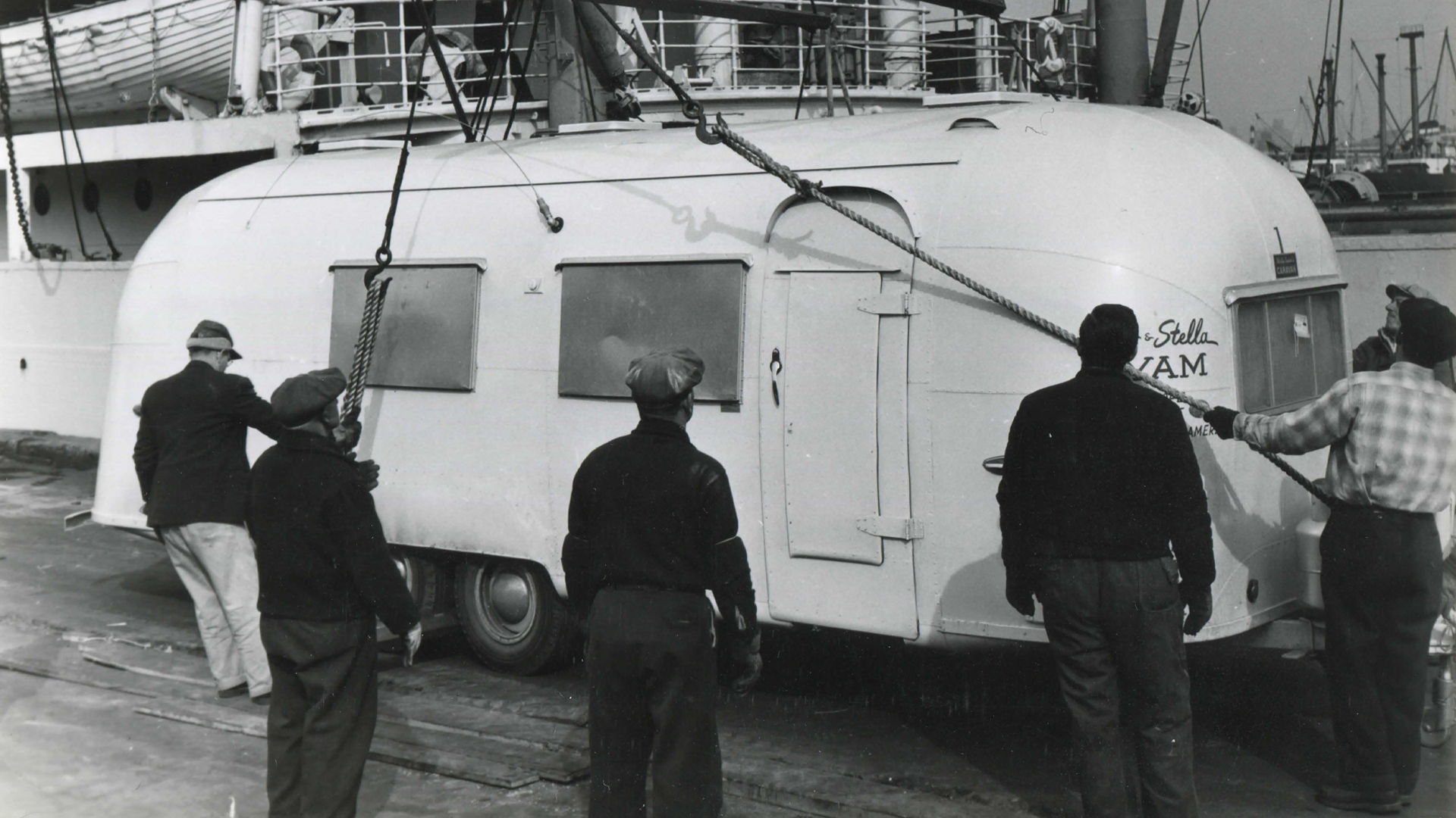 Vintage Airstream White Trailer being moved onto a ship to go to Europe