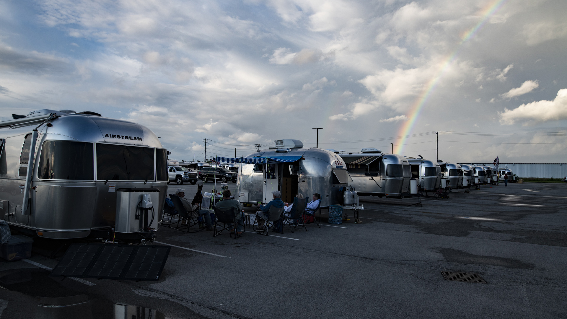 Airstream Travel Trailers parked in a parking lot at Airstream Headquarters in Jackson Center, OH with a rainbow in the sky.