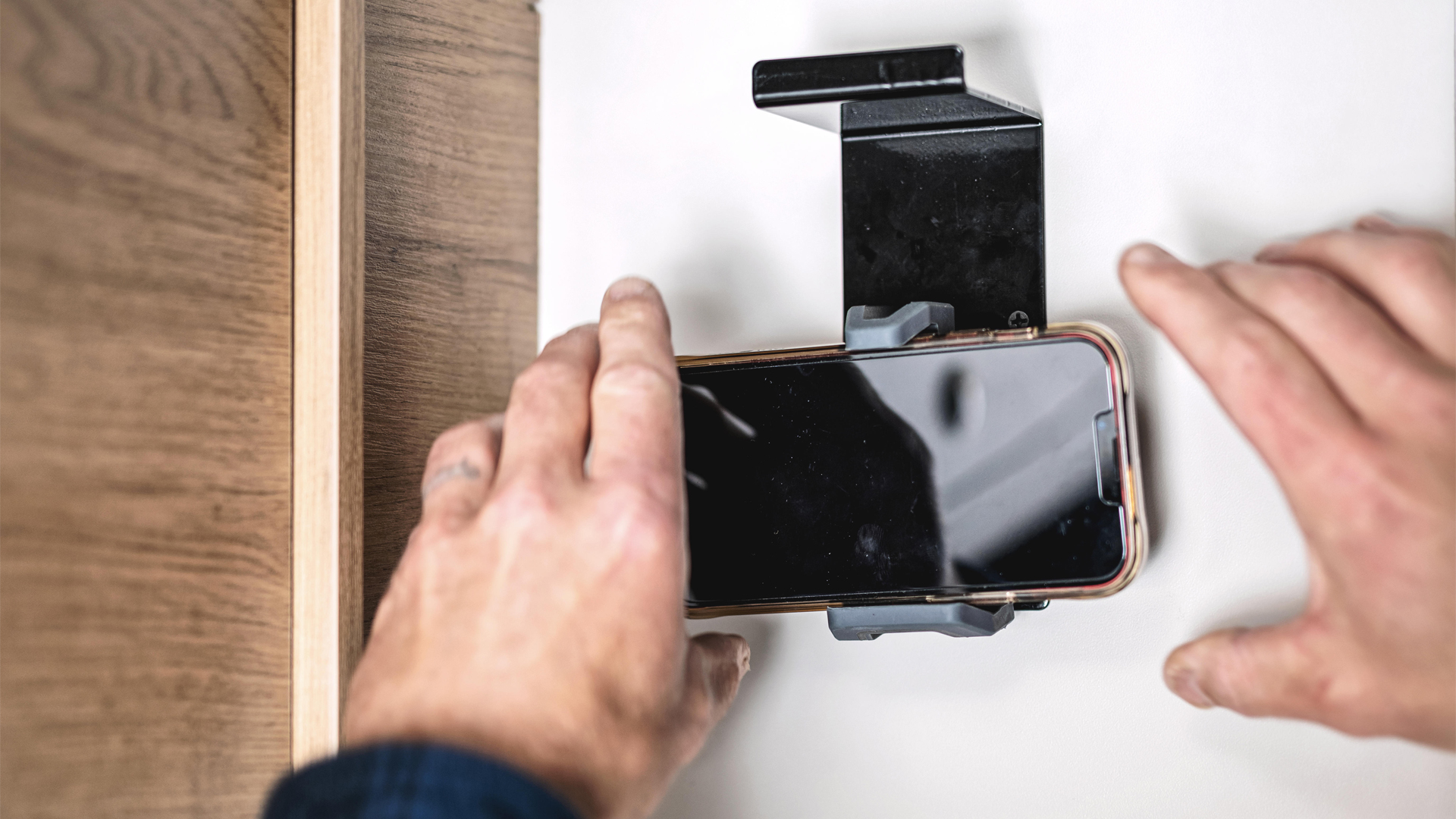 A person putting their phone on the phone holder in the Airstream Rangeline Touring Coach