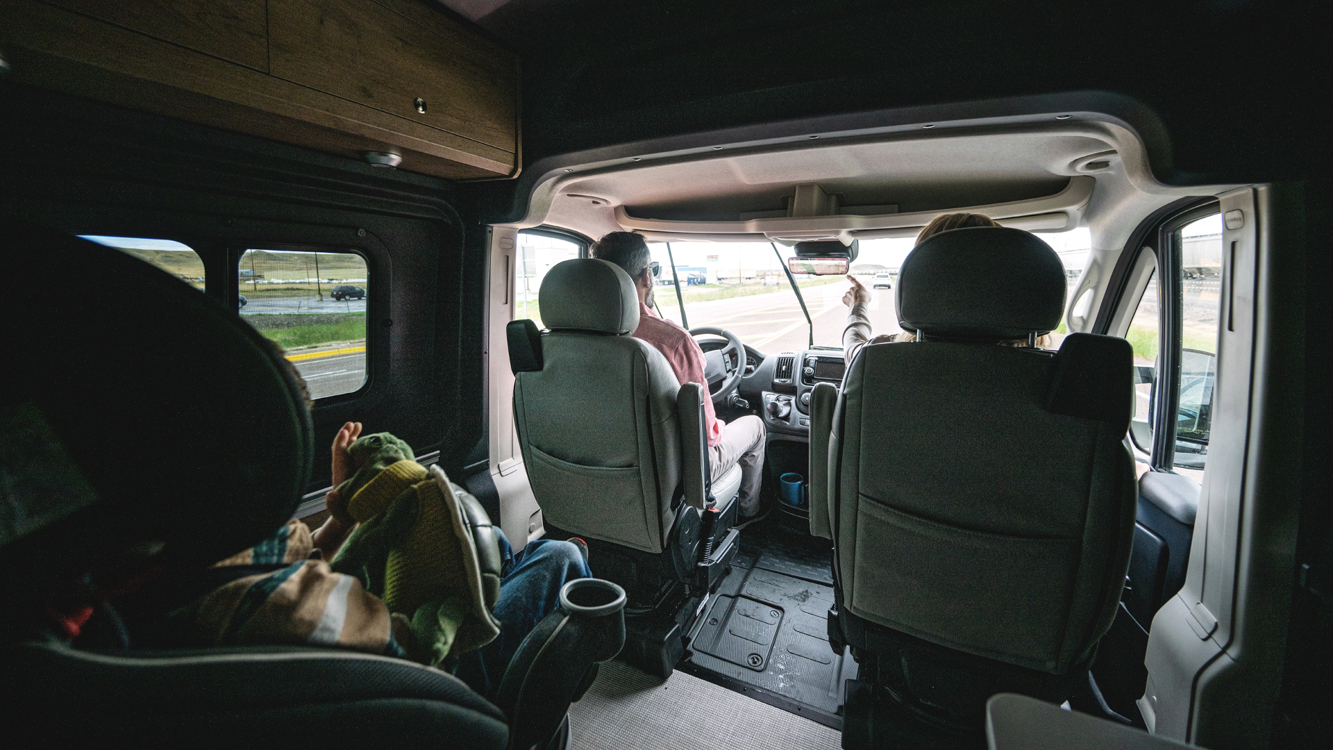Two adults and a child buckled in and riding in the Airstream Rangeline Touring Coach.