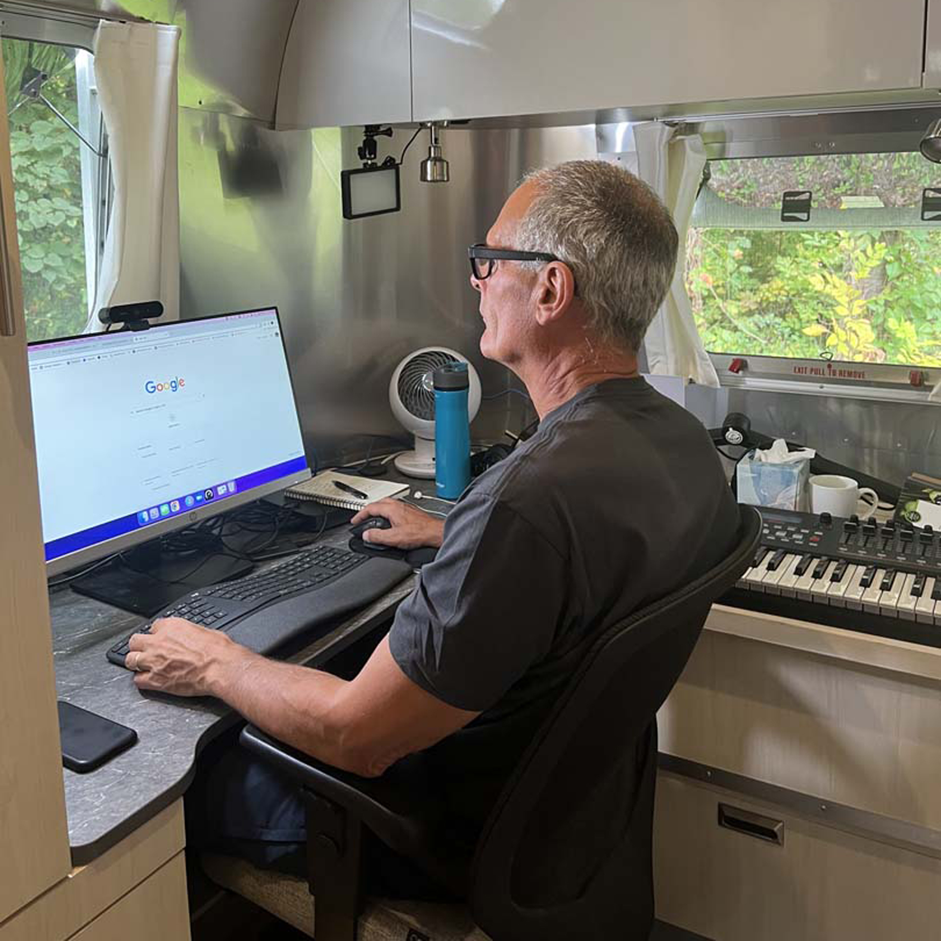 A man working from anywhere in his Airstream Flying Cloud office camper.