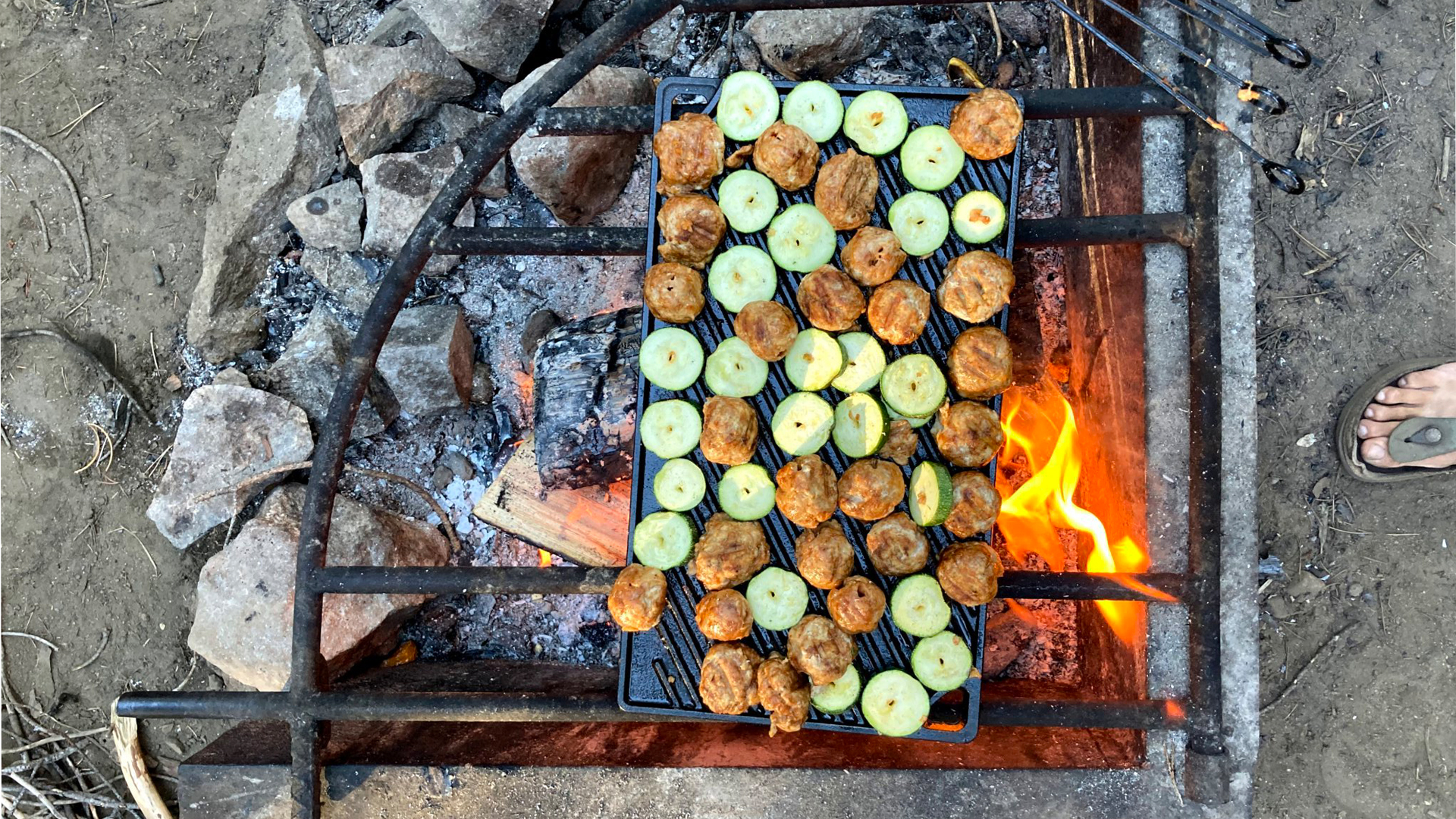 Vegetables cooking on a grill over a fire.