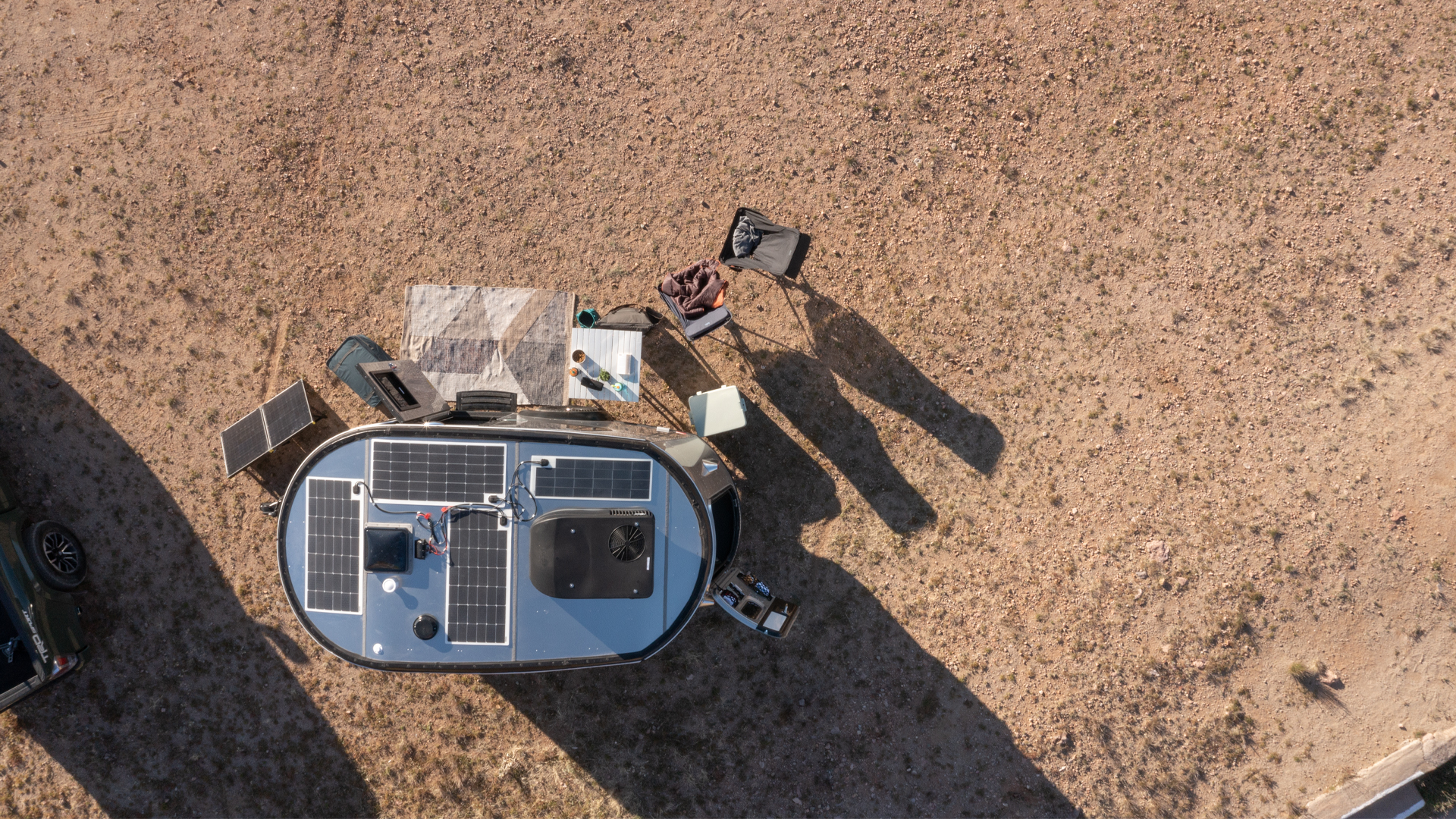 The REI Co-op Airstream Basecamp travel trailer sitting in the dessert in Arizona with the overhead view of the solar panels.