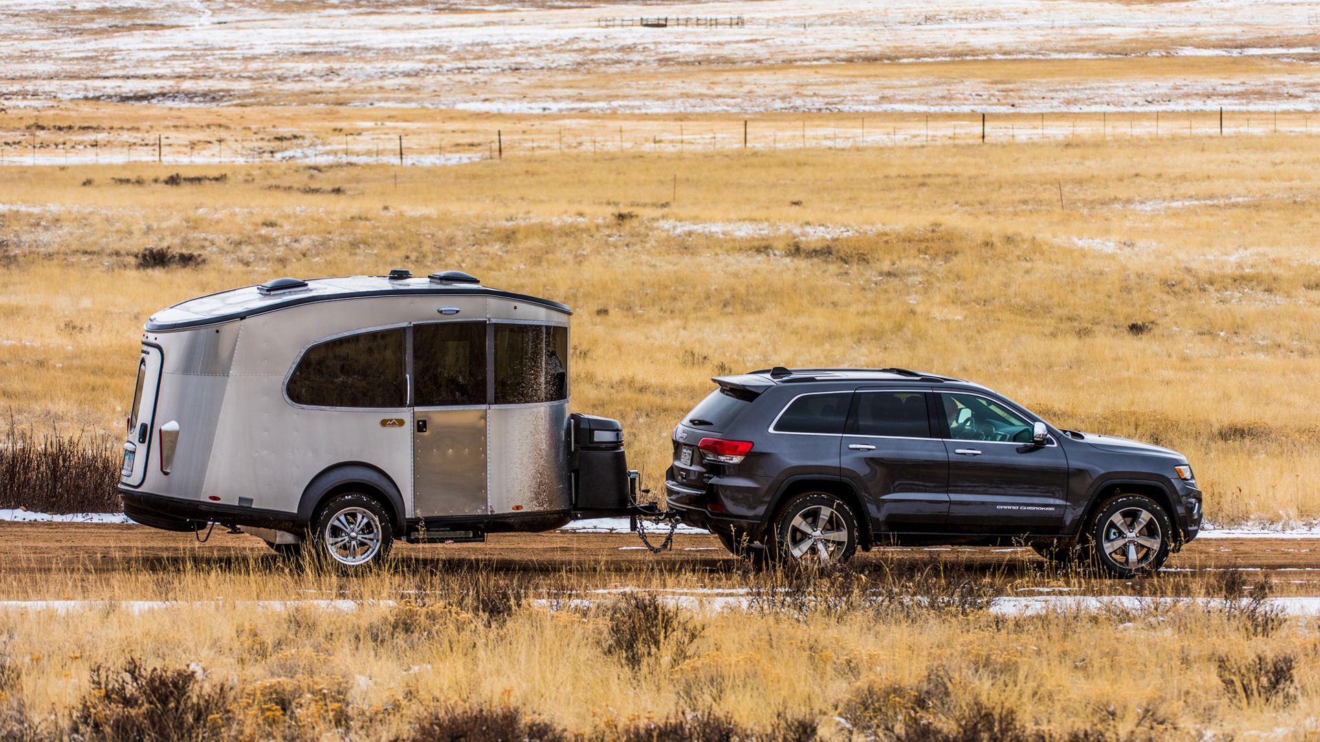 A SUV towing an Airstream Basecamp travel trailer.