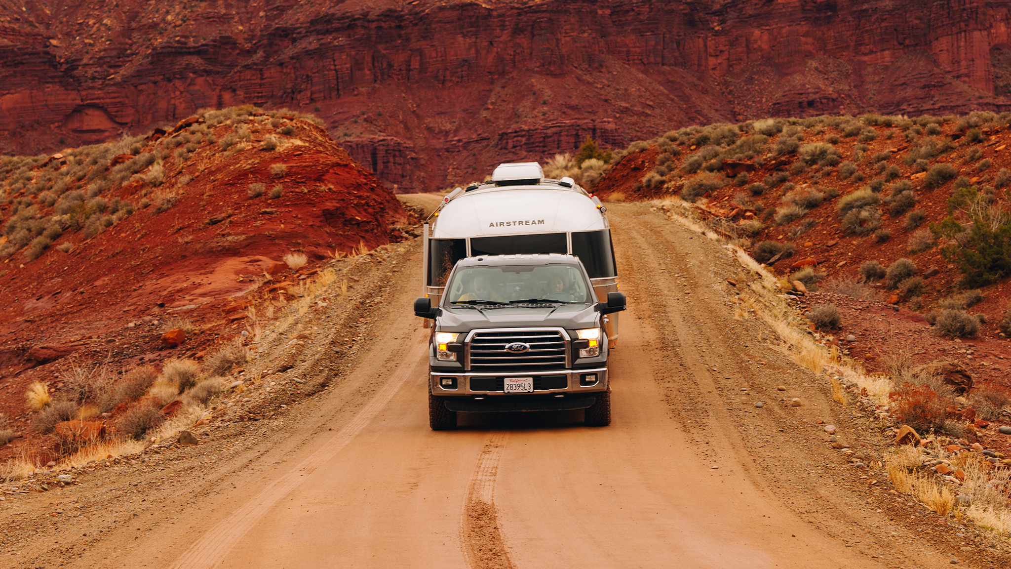 A truck towing an Airstream travel trailer in the desert.