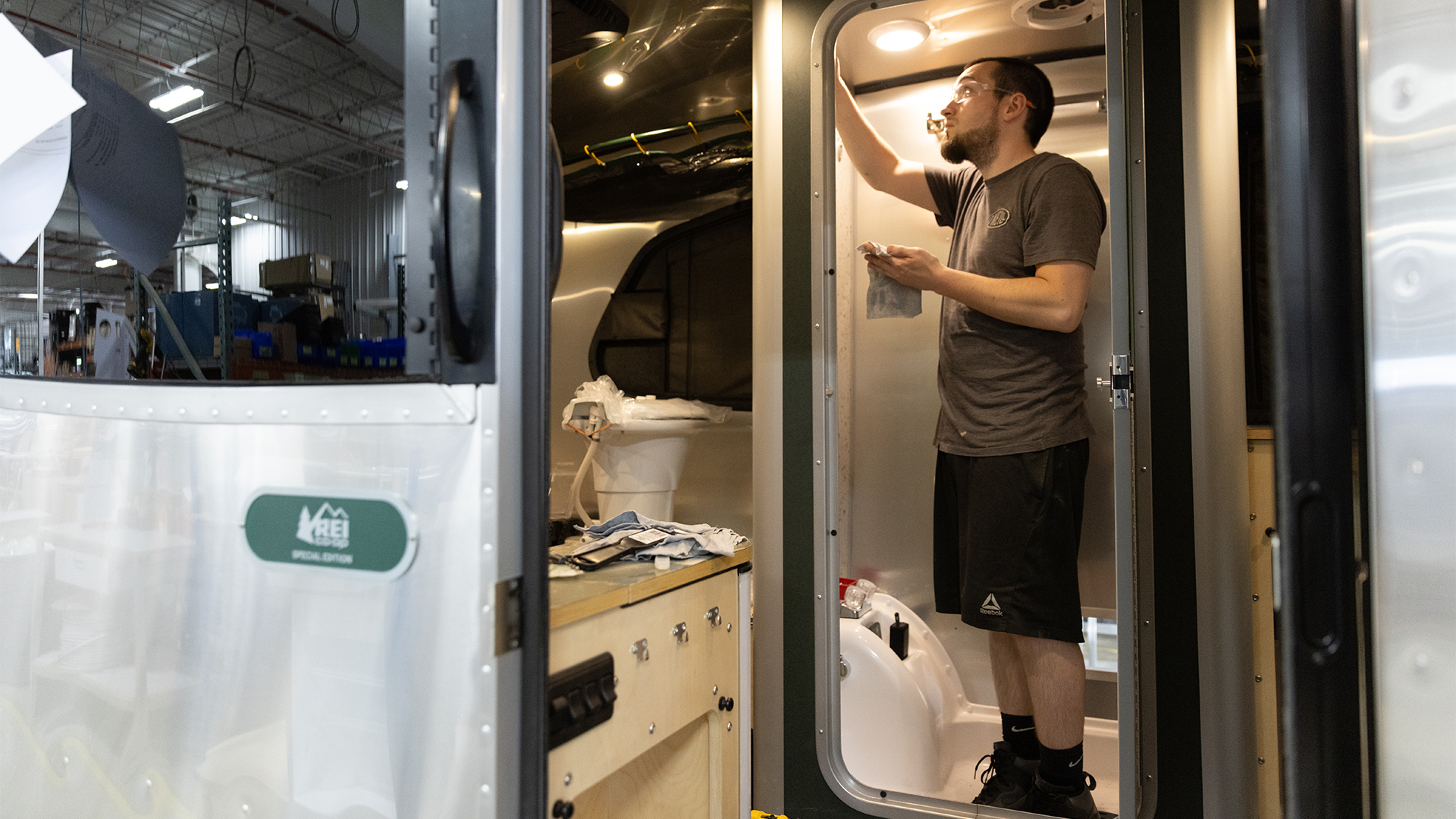 An Airstream employee working on building the interior of an Airstream Basecamp travel trailer