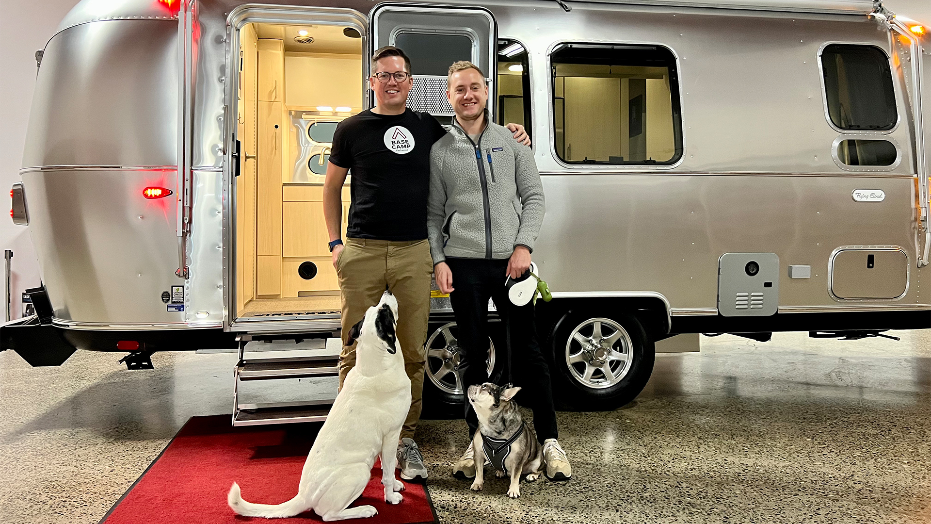 Joe and Conner next to their new Airstream Flying Cloud travel trailer with their two dogs.